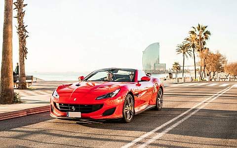 Along the beach in a red Ferrari California