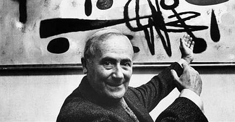 The artist Joan Miró in front of one of his works